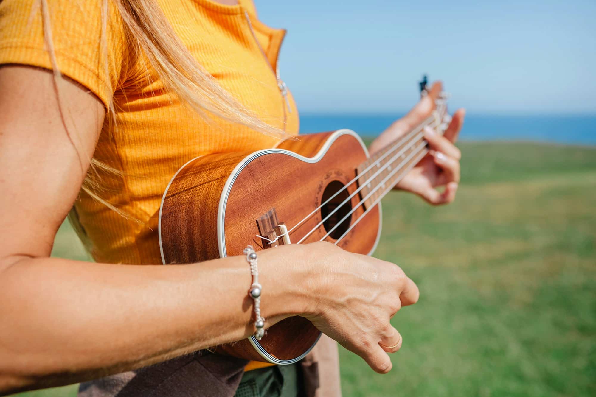 Unrecognizable woman playing the ukulele
